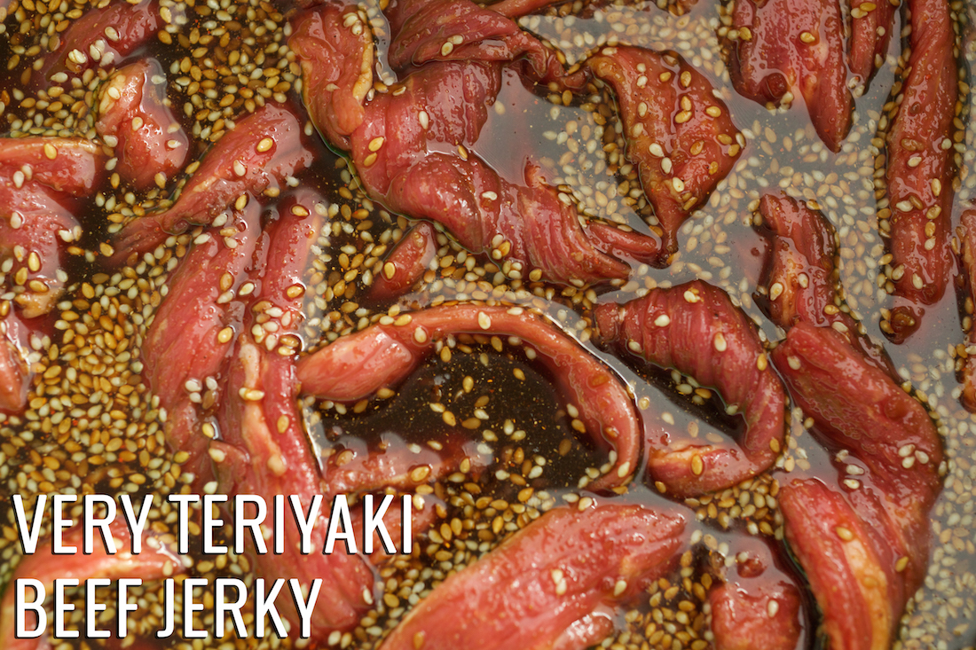 Raw slices of beef jerk in teriyaki marinade. Text reads "Very Teriyaki Beef Jerky".