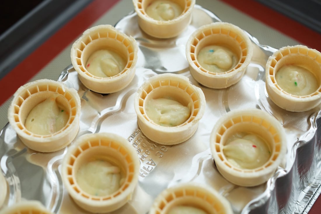 Ice cream cones filled with cupcake batter before going in the oven.