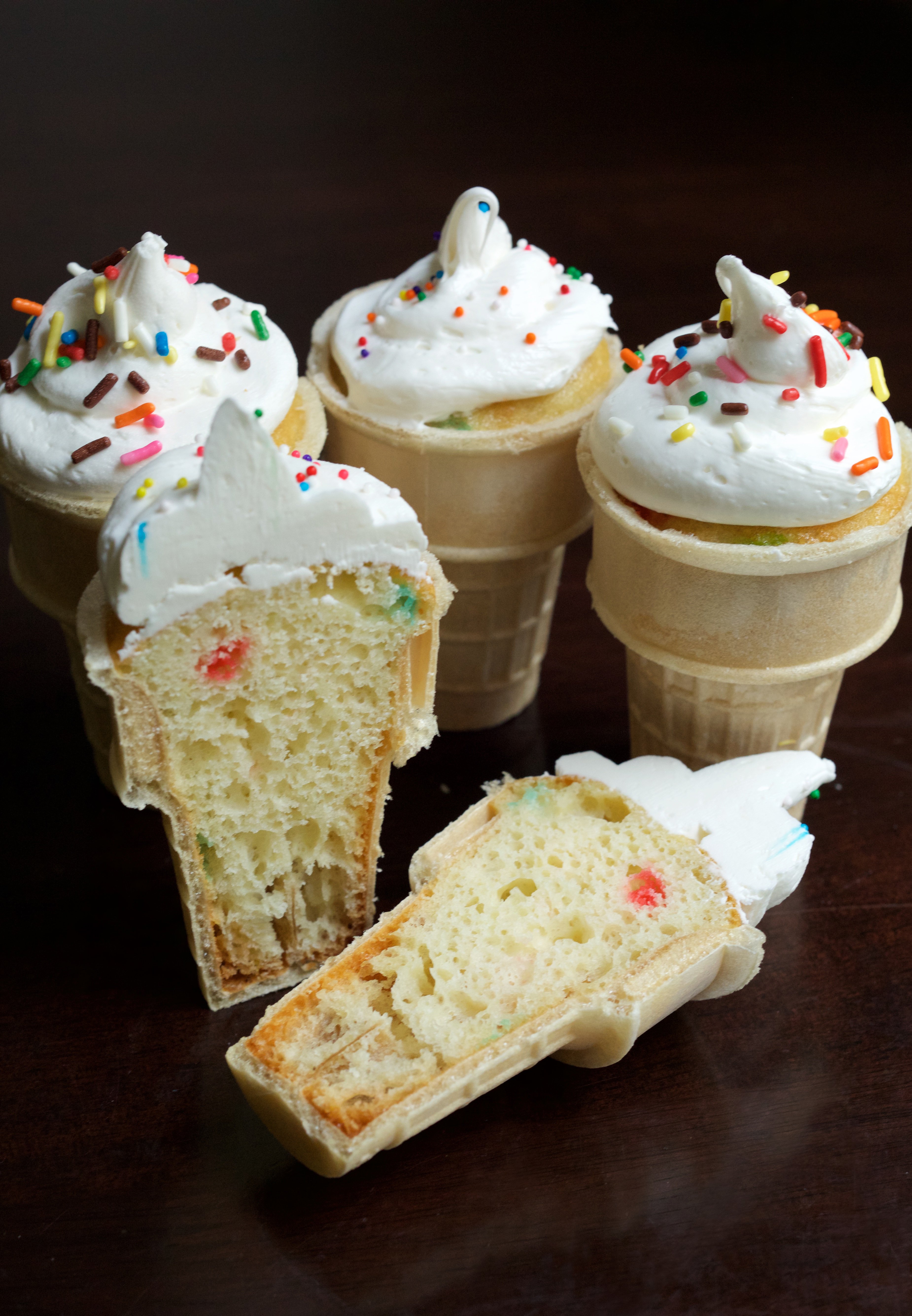 Ice Cream Cone Cupcakes on a black background. One cone has been cut open to show the cupcake inside.