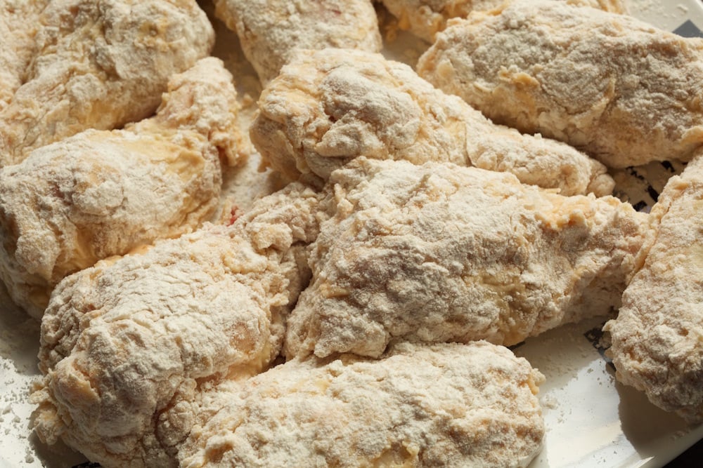 Wings coated in buttermilk and flour before frying.