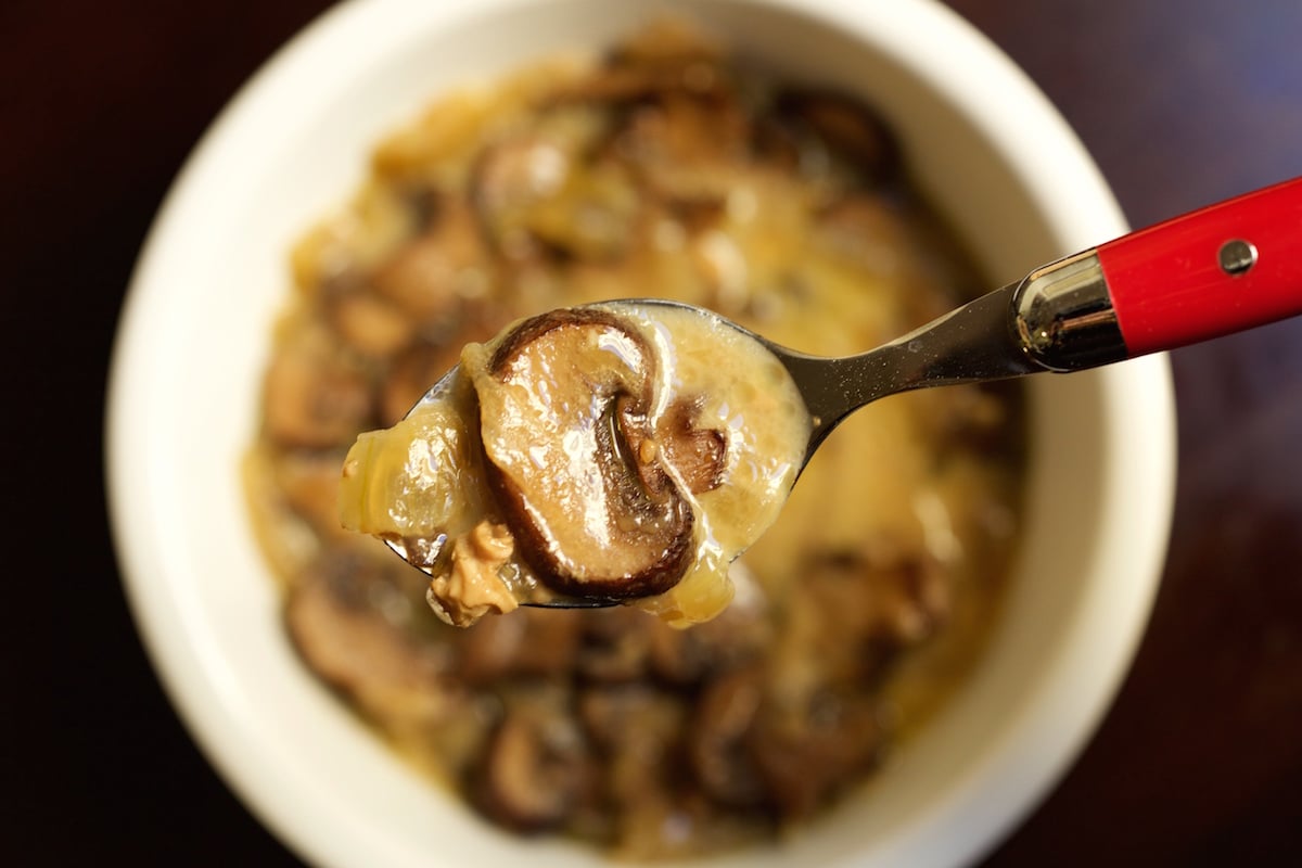 A spoonful of Brie & Mushroom Soup held over the bowl