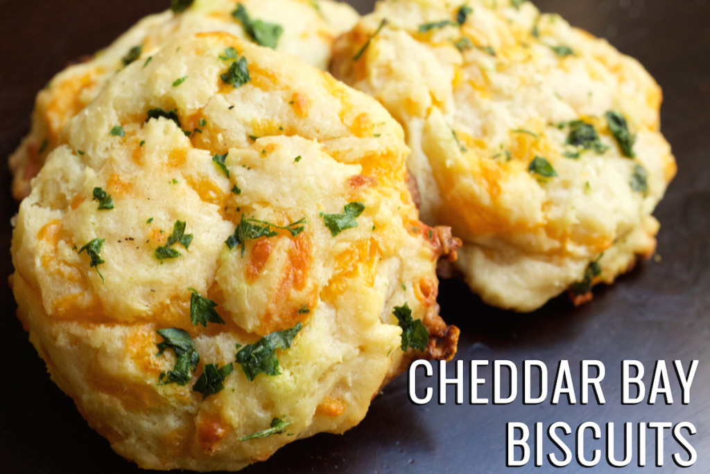 Three copycat Red Lobster Cheddar Bay Biscuits on a black background. Text in the lower right hand corner reads "cheddar bay biscuits".