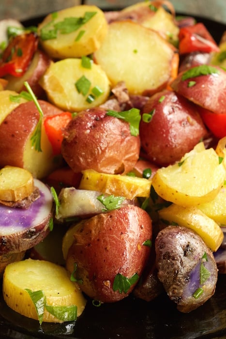 A close up of July 4th potato salad with red, yellow, and purple potatoes.