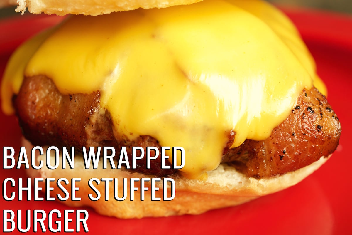 Close up of a bacon wrapped burger oozing with cheese on top. Text reads "Bacon Wrapped Cheese Stuffed Burger"