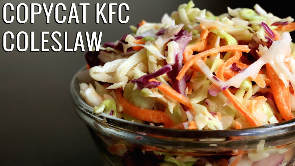 A small glass bowl filled with coleslaw on a black background. Text reads "Copycat KFC Coleslaw".