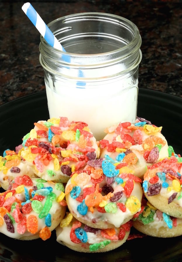 Mini Fruity Pebbles Donuts in front of a glass of milk.