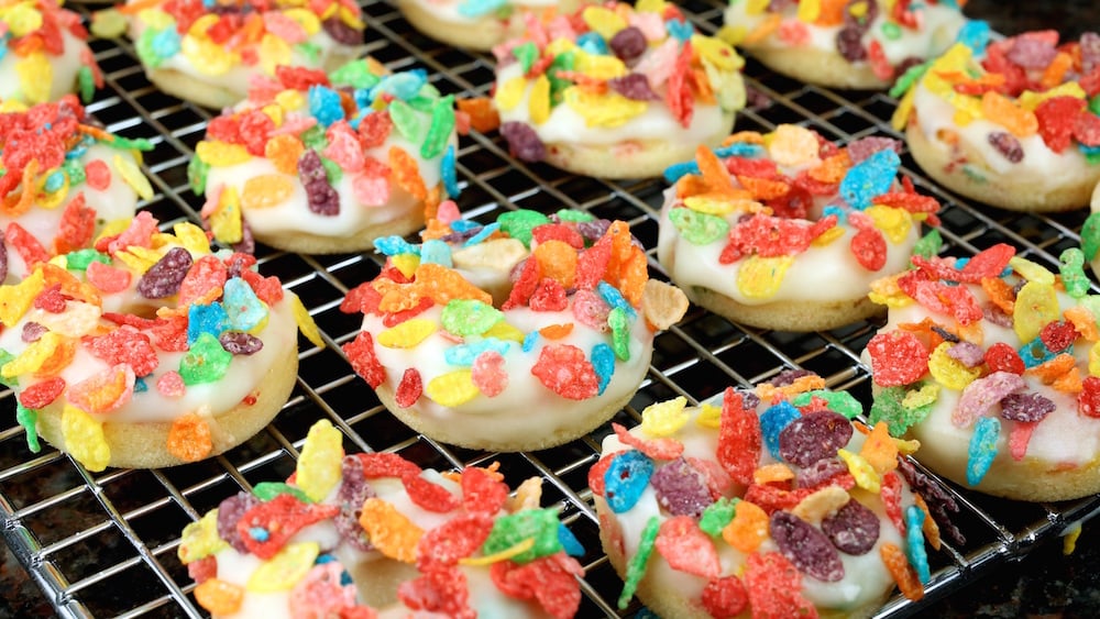 Mini Fruity Pebbles Donuts on a cooling rack.