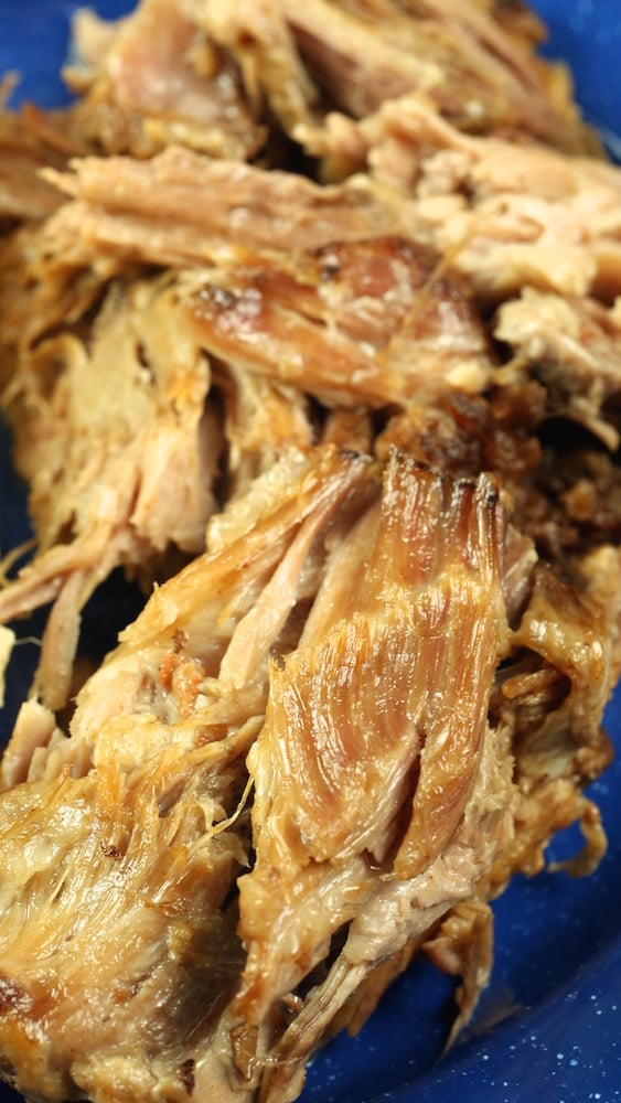 Crock Pot Kalua Pork shredded and served on a blue plate