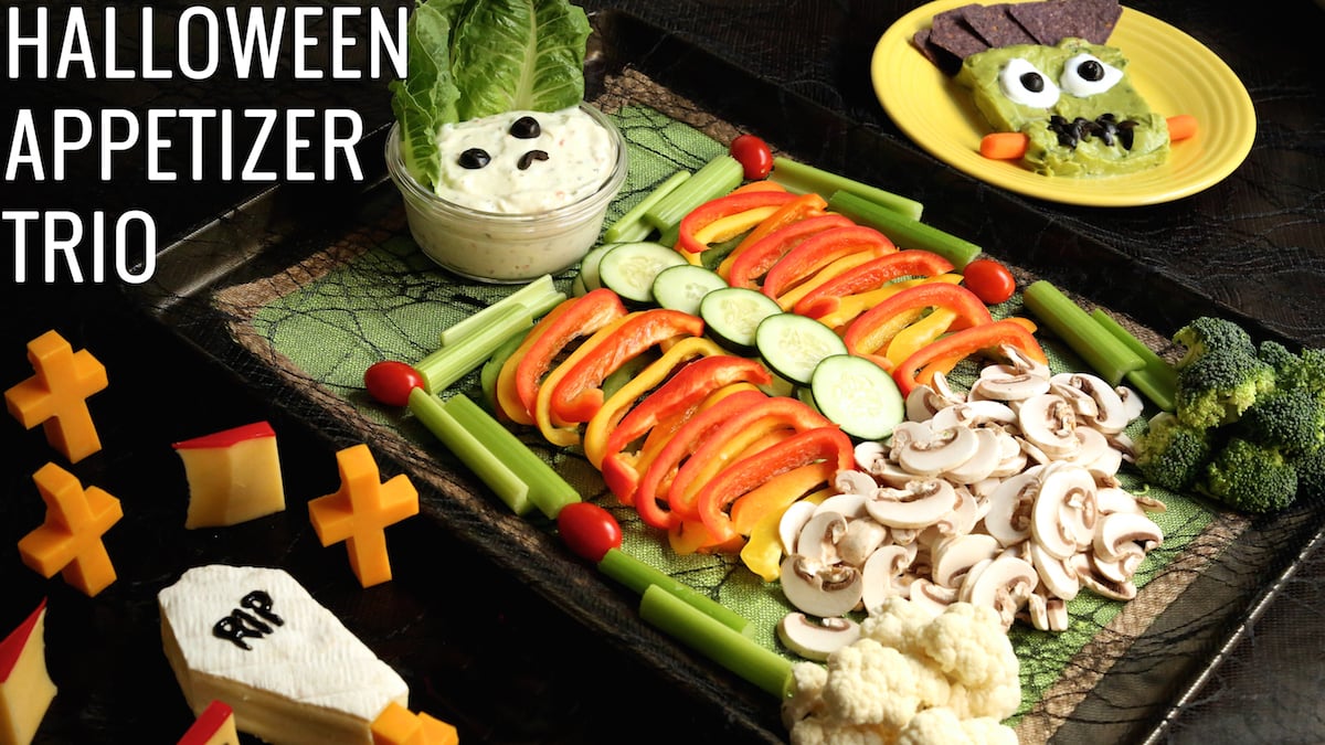 A grave yard made of cheese next to a skeleton shaped veggie tray.