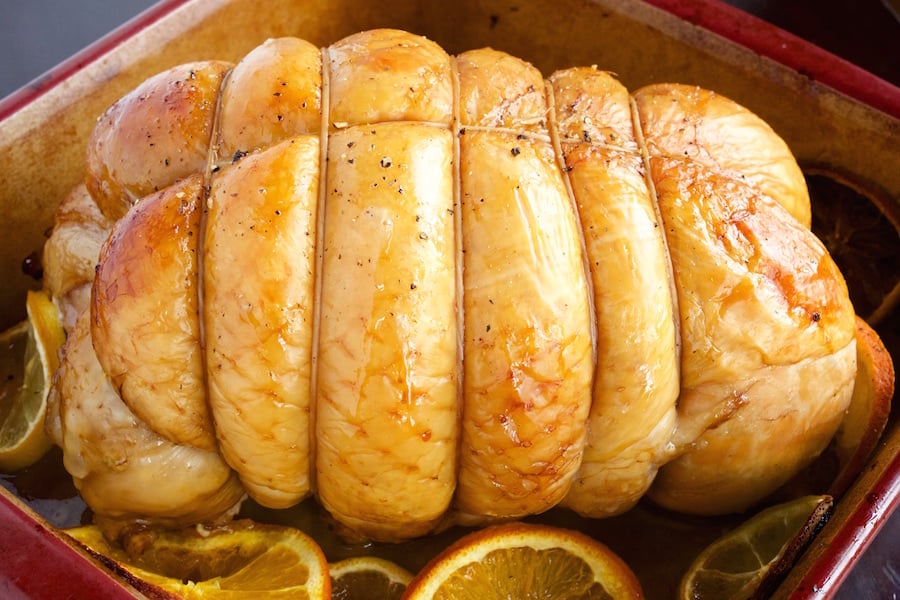 Sweet Tea Brined Turkey in a small baking dish surrounded by sliced citrus.