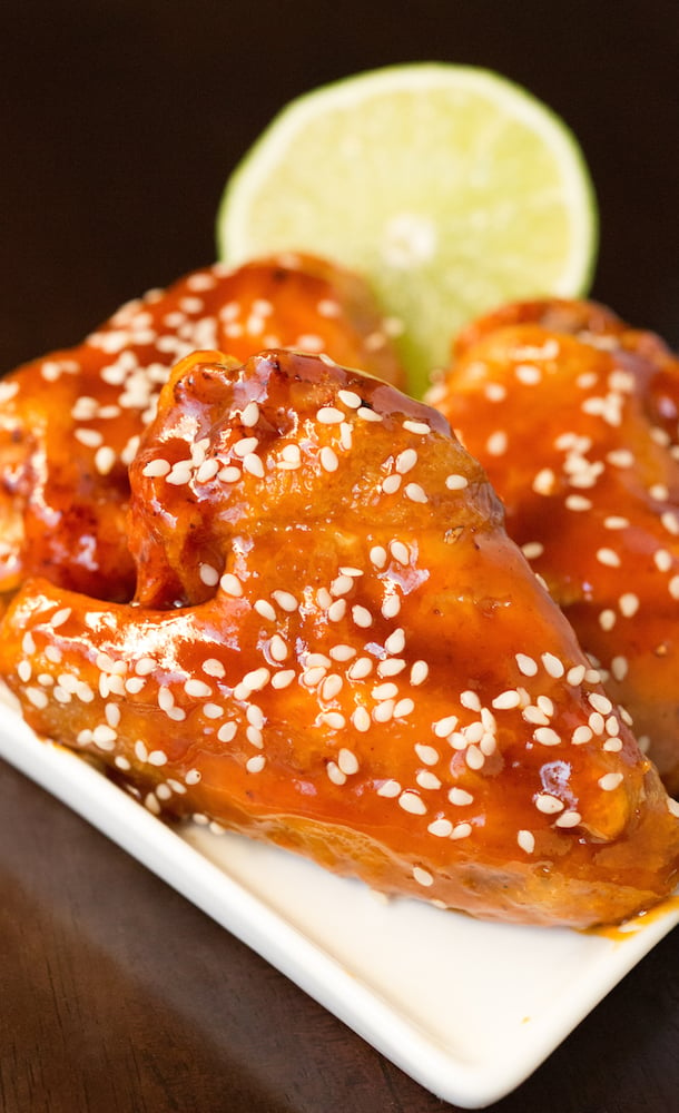 A close up of the sriracha honey lime wings with a half lime in the back.