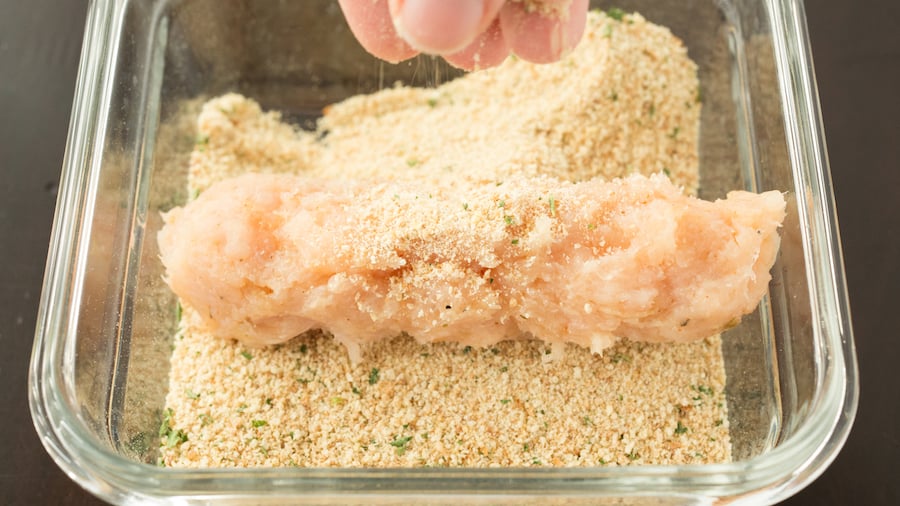 The cheese stick covered in ground chicken is now being coated in panko