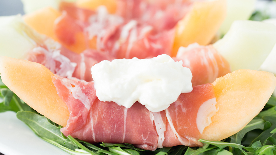 Cantaloupe & honeydew melon wrapped in prosciutto then topped with creamy burrata and served on a bed of arugula. 