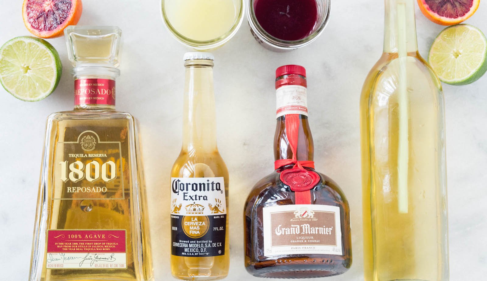 All the ingredients to make our Coronarita (Beer Margarita) Recipe: lemon juice, blood orange juice, lemongrass simple syrup, coronita, tequila, and Grand Marnier. 