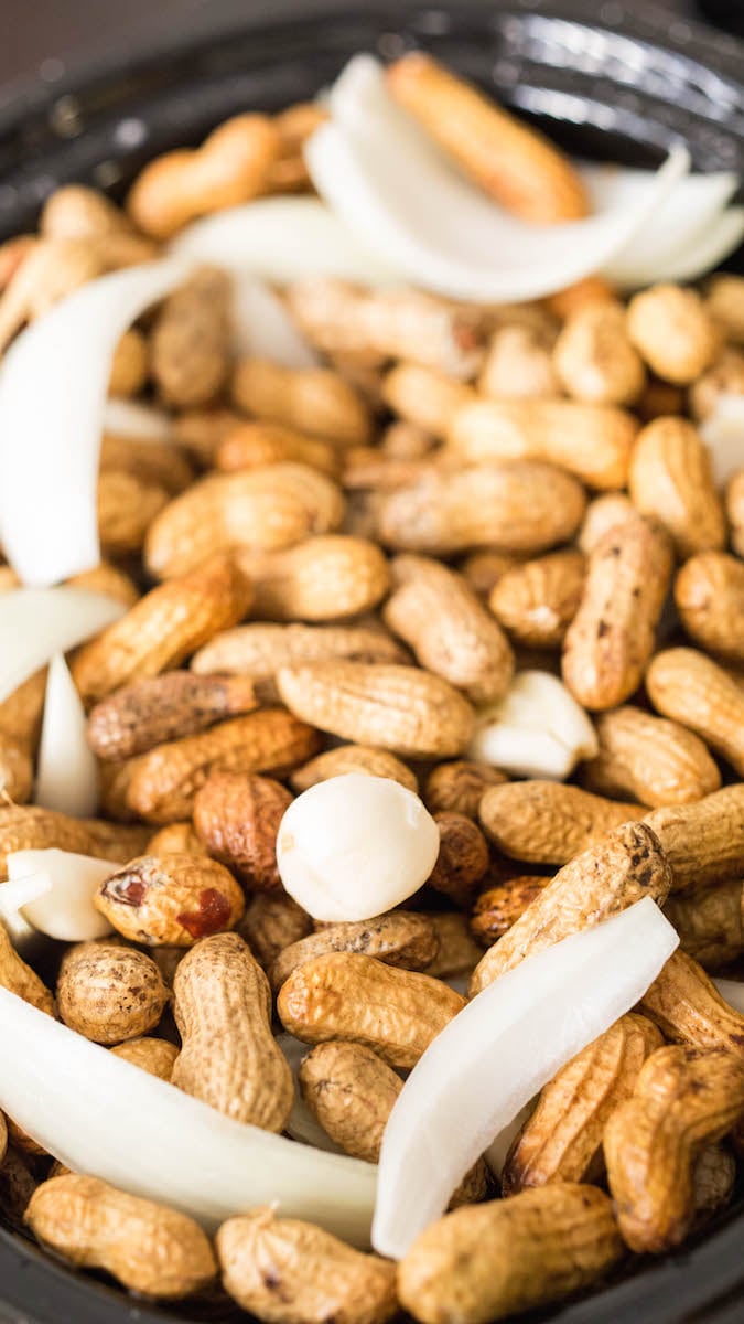 Peanuts in the crock pot with raw garlic and sliced onion.