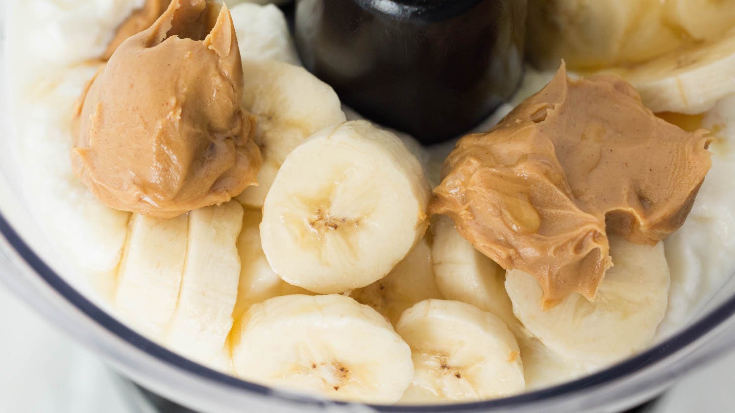 Food processor with yogurt peanut butter banana dog treat ingredients.