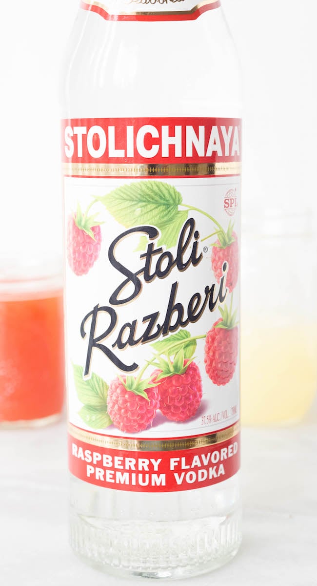A bottle of Stoli raspberry flavored vodka on a white background.