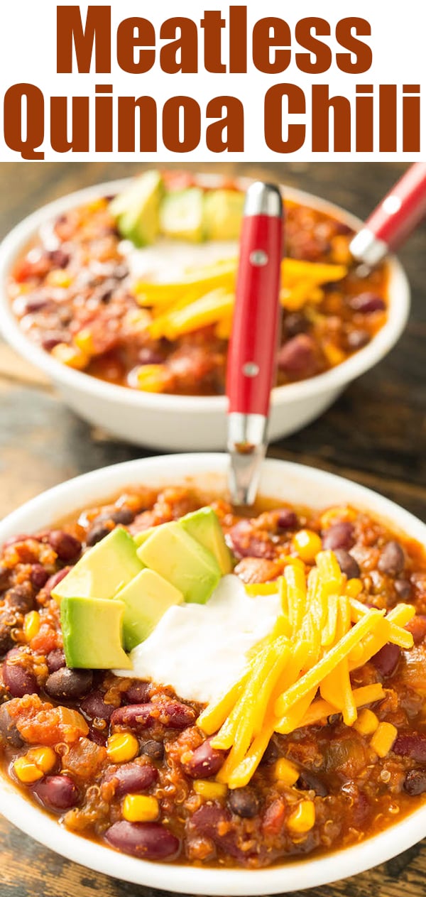 Two bowls of meatless quinoa chili sit on a wood background. The bowls of chili have been garnished with shredded cheddar cheese, a dollop of sour cream, and some chopped avocado. Text at the top reads "meatless quinoa chili".