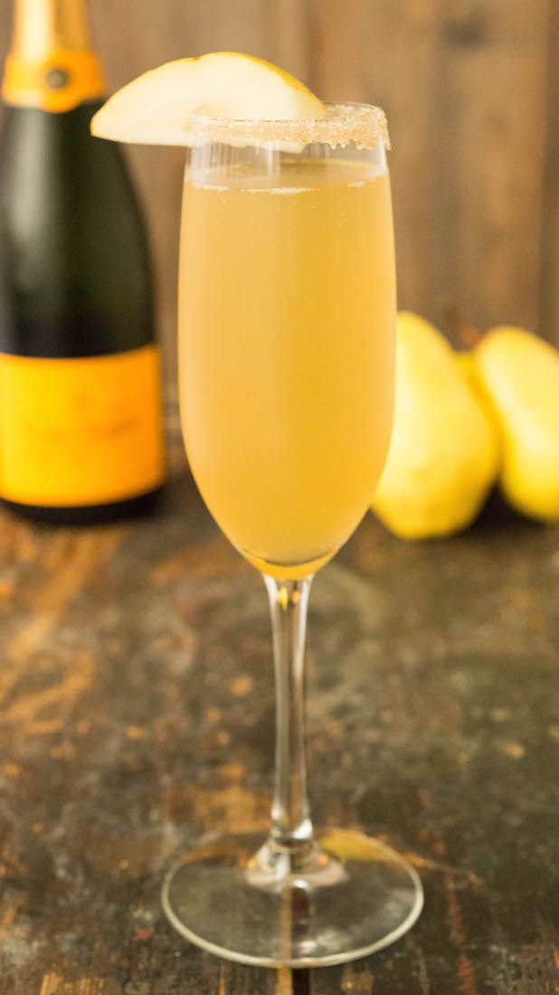 A champagne flute filled with a vanilla bean pear mimosa.