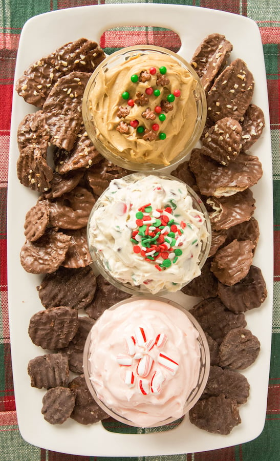 Overhead view of a Christmas Dessert Dip Platter with Christmas Cookie Dough Dip, Gingerbread Dip, Peppermint Fluff Dip with Chocolate Wavy Lay's Chips For Dipping.