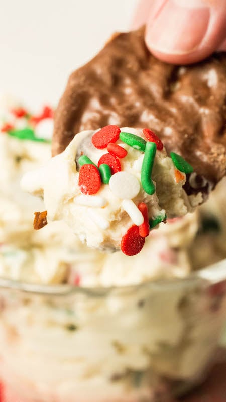 A chocolate potato chip that has been dipped in Christmas Cookie Dough Dip.