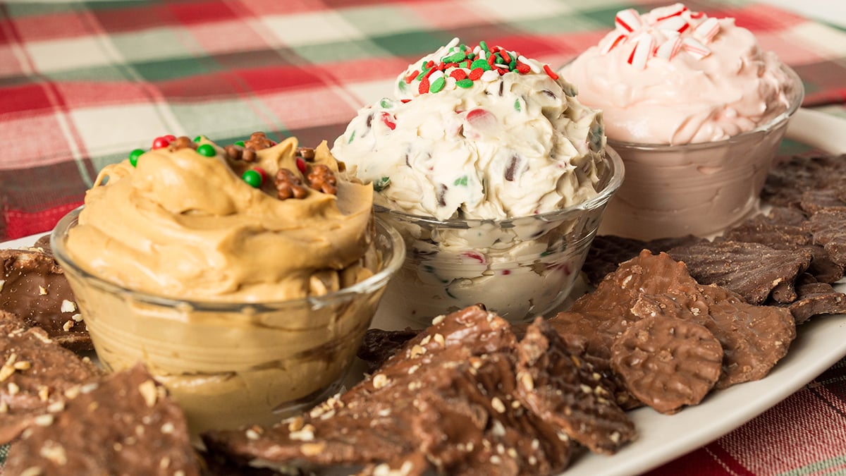 A trio of dessert dip recipes: Christmas Cookie Dough Dip, Gingerbread Dip, and Peppermint Fluff. Served with Chocolate Wavy Lay's Potato Chips.