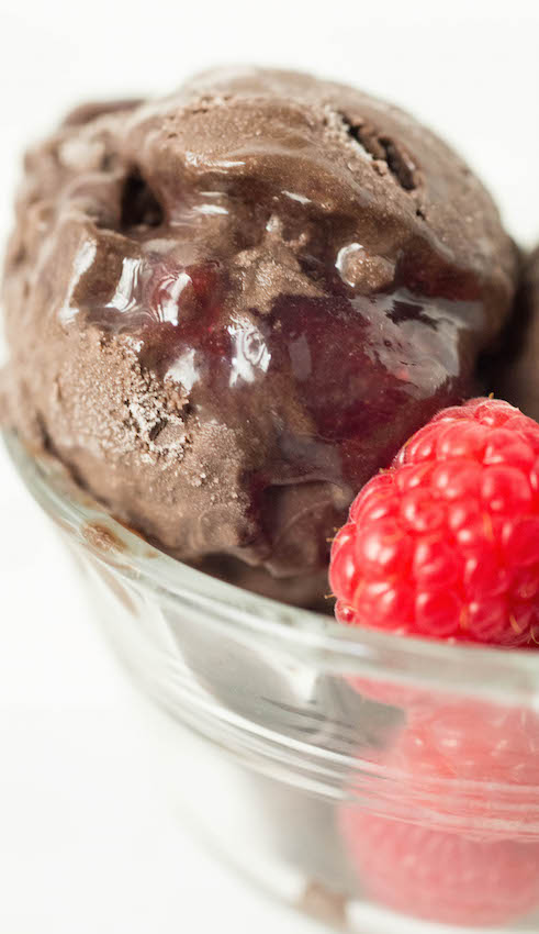 Close up of a scoop of Dark Chocolate Raspberry Gelato in a glass bowl.