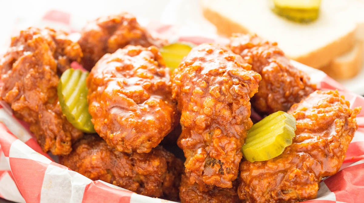 Nashville Hot Chicken Wings in a basket garnished with pickle slices.