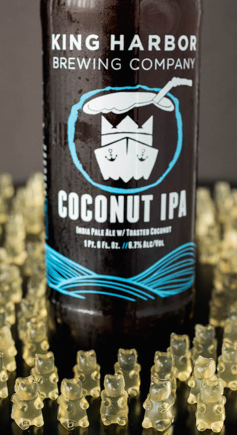 A coconut IPA beer bottle surrounded by beer gummy bears.