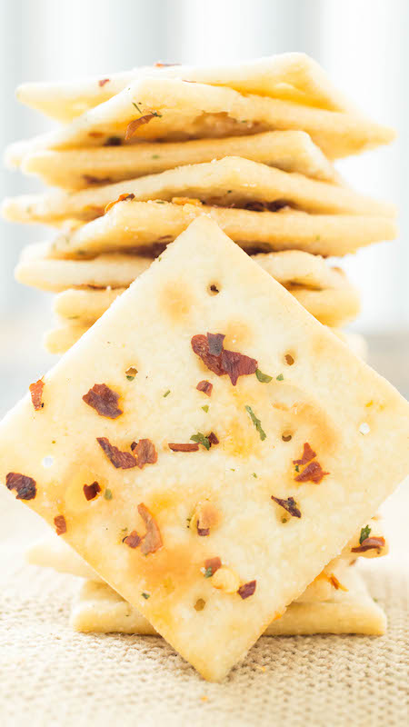 Fire Crackers Recipe (Saltines seasoned with ranch, and red pepper flakes) are stacked on top of one another.