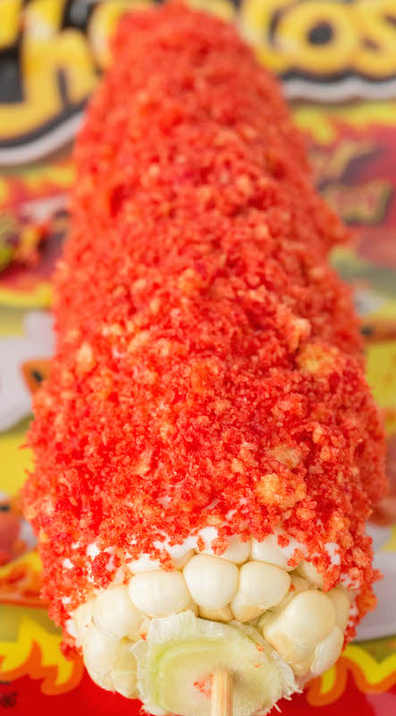Close up of Flamin' Hot Cheetos Mexican Street Corn Recipe with a bag of the chips out of focus in the background.