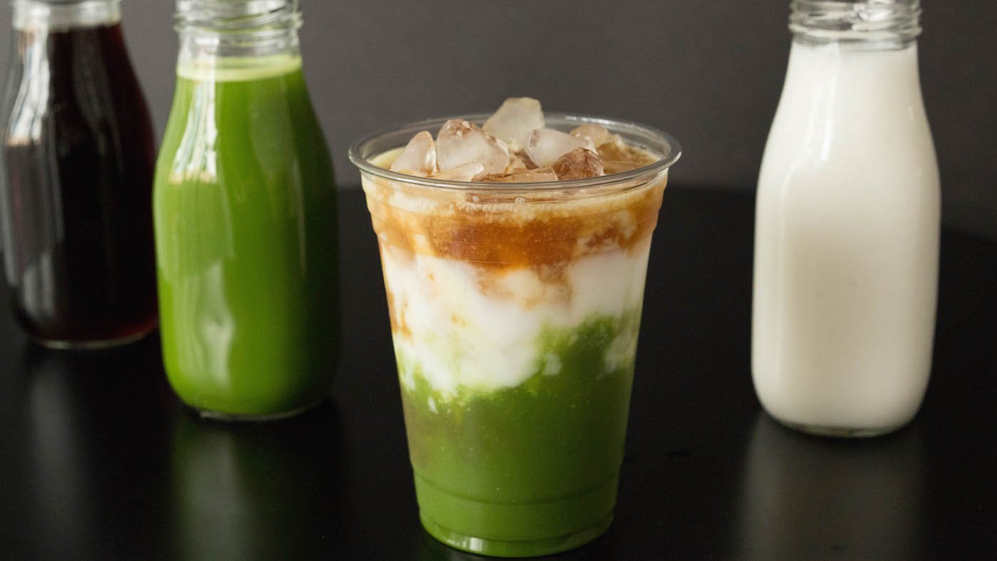 Starbucks Copycat Matcha Espresso Fusion Latte in front of bottles of coffee, matcha, and milk.
