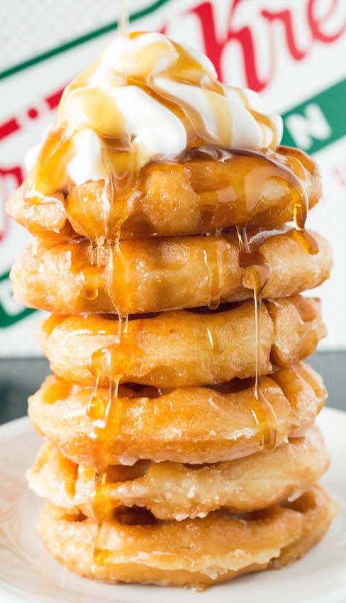 Close up of a stack of Krispy Kreme Waffle Donuts that have been drenched in syrup and topped with whipped cream.