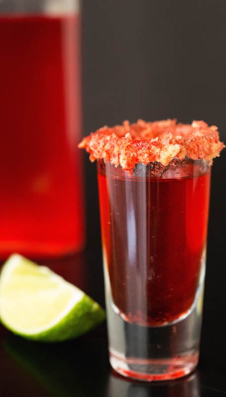 A shot of Flamin' Hot Cheetos Vodka with a lime slice in the background.