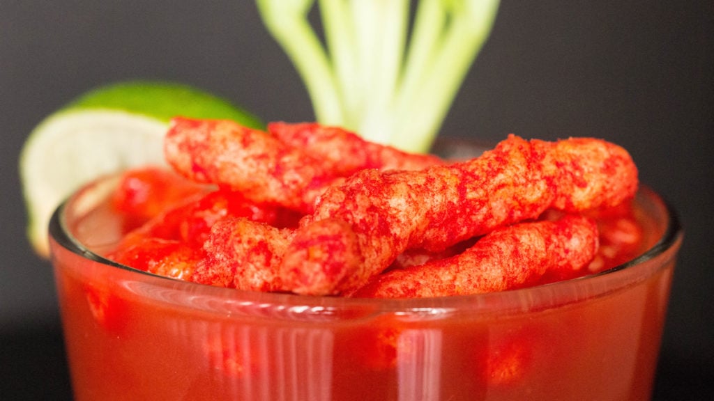 Close up of Flamin' Hot Cheetos on top of a Bloody Mary.