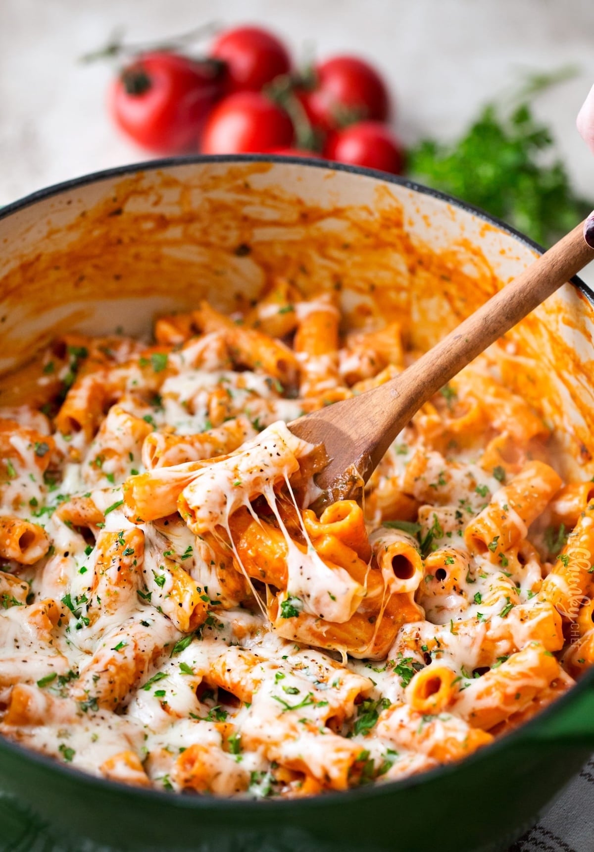 A large pot filled with pasta coated in red sauce and melted mozzarella cheese.