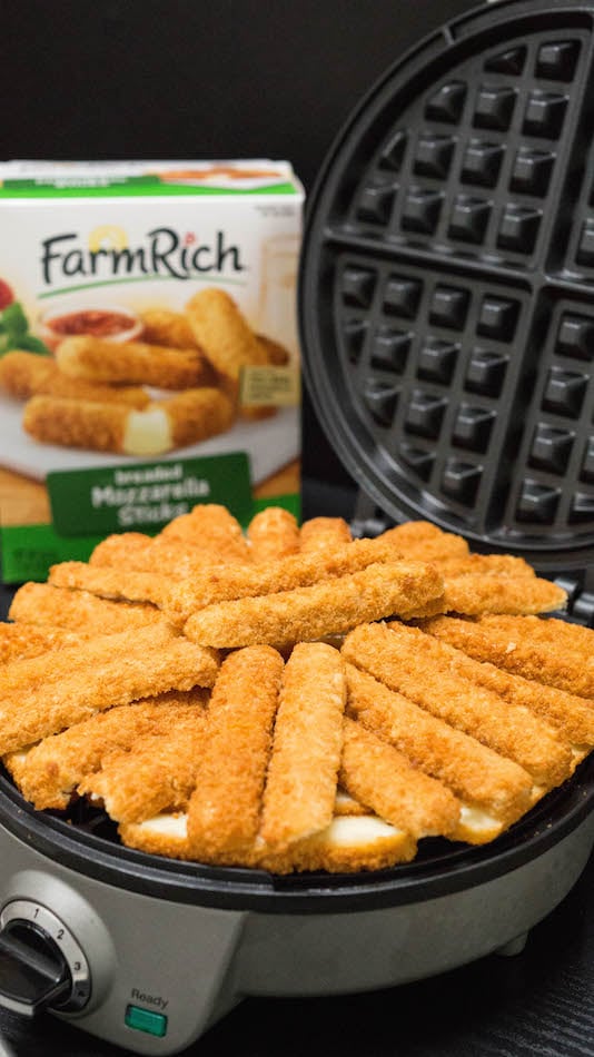 A waffle maker filled with mozzarella sticks.