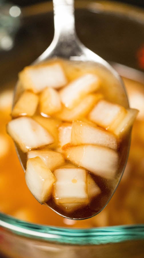 A spoon holding up chicken marinade. 