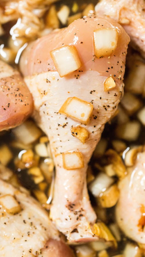 A raw chicken drum stick in marinade. 