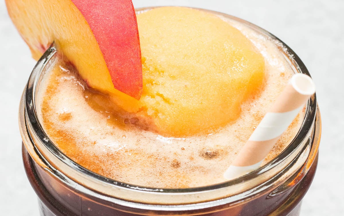 Close up of the top of a Peach Tea Float garnished with a peach slice.