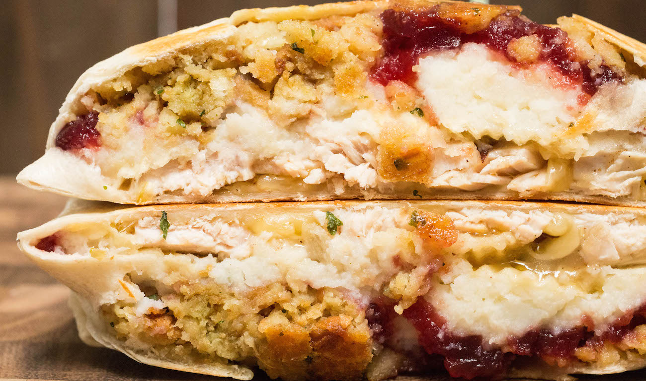 Close up of a Thanksgiving Leftovers Crunchwrap Supreme that's been cut in half to show the food inside.