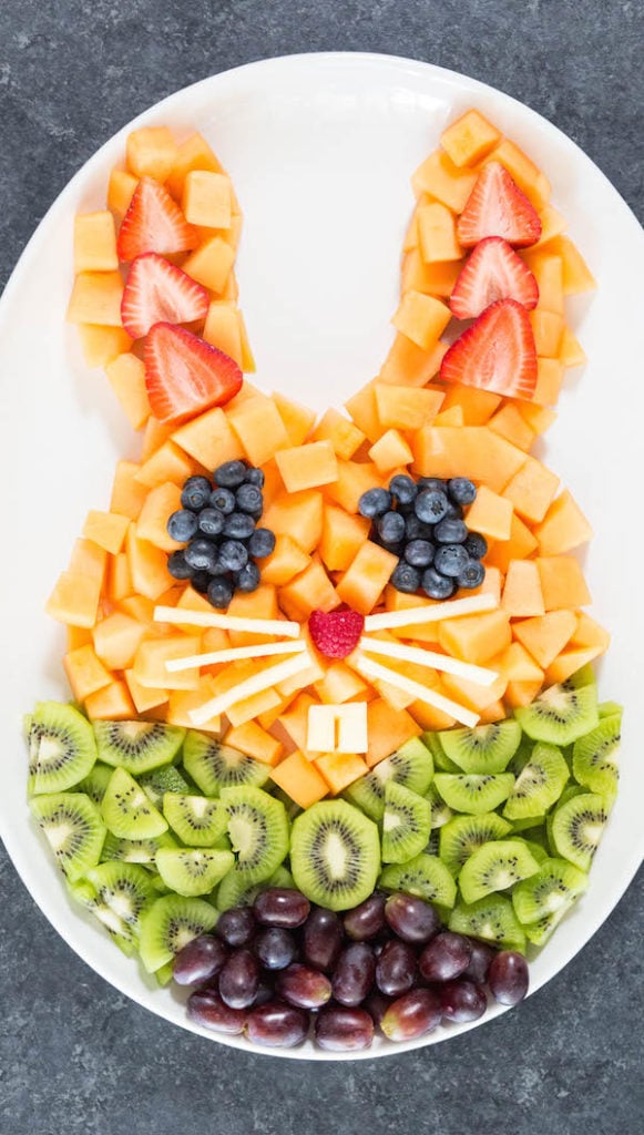 Easter bunny shaped fruit tray with cantalope, kiwi, grapes, blueberries, and strawberries.