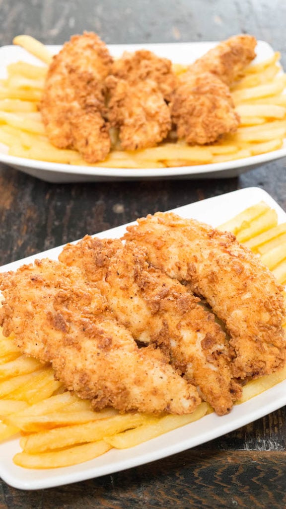Two white baskets filled with French fries and crispy buttermilk chicken tenders.