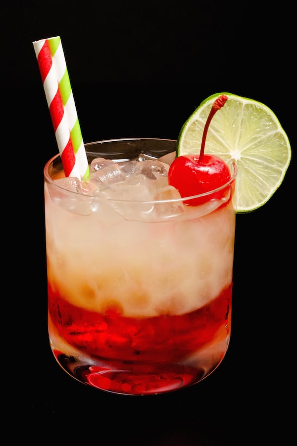 A Cherry Limeade Cocktail on a black background.