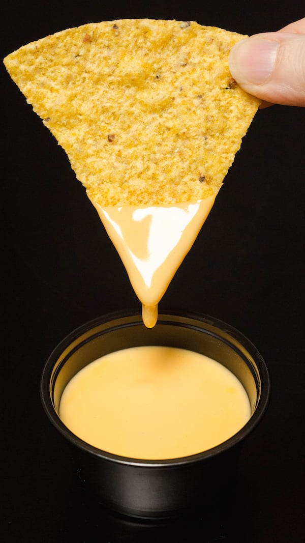 Copycat Taco Bell Cheese dripping from a tortilla chip.