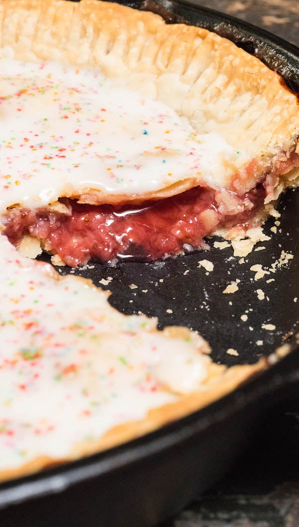 Strawberry Pop Tart Pie after it's been sliced and the strawberry filling is oozing out.