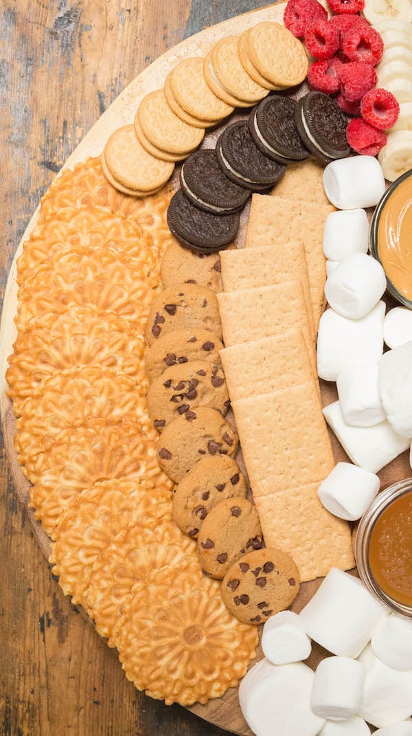  Graham Crackers, Oreos, and Chocolate Chip Cookies on a s'mores board.