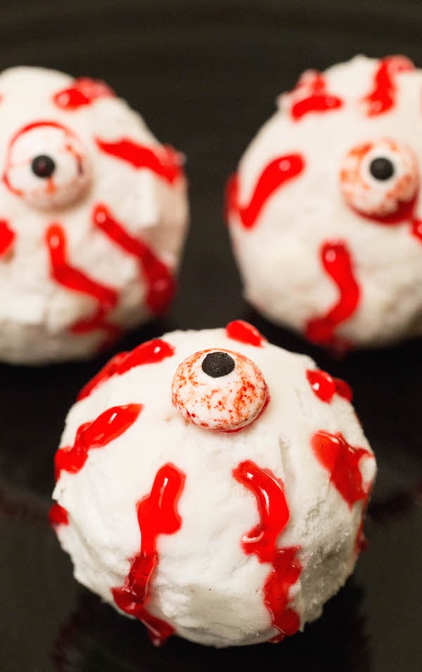 Three white donut holes decorated to look like bloody monster eyeballs