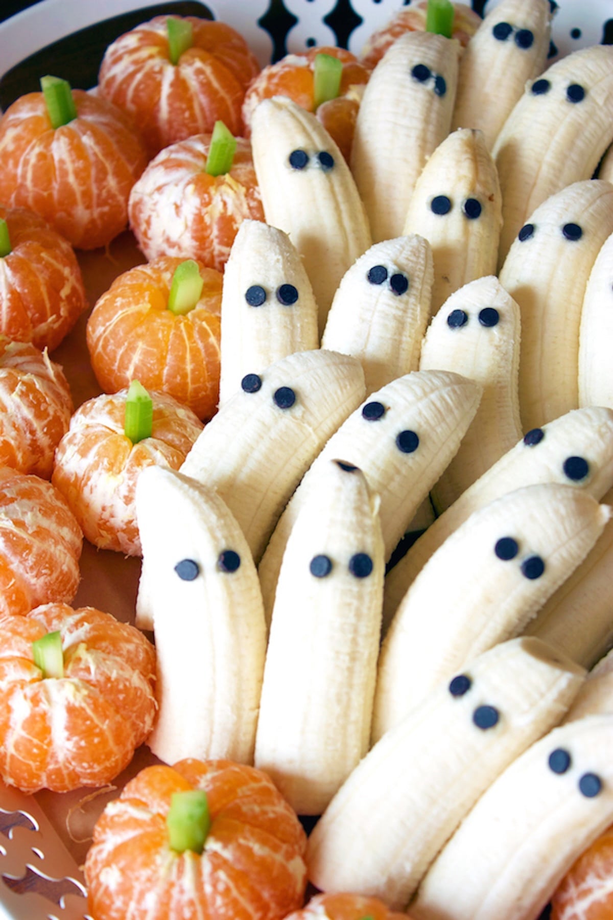 Peeled mandarin oranges have celery sticks sticking out of the top to look like pumpkins, and bananas have been peeled and adorned with two chocolate chip eyes each to resemble ghosts.