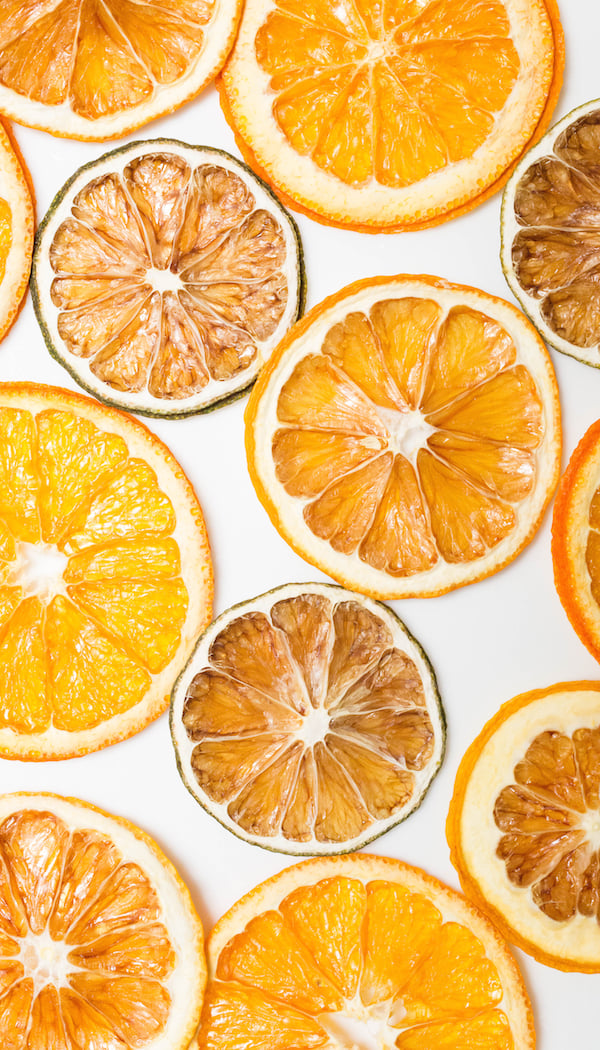 Dehydrated lime, orange, and lemon slices on a white background.
